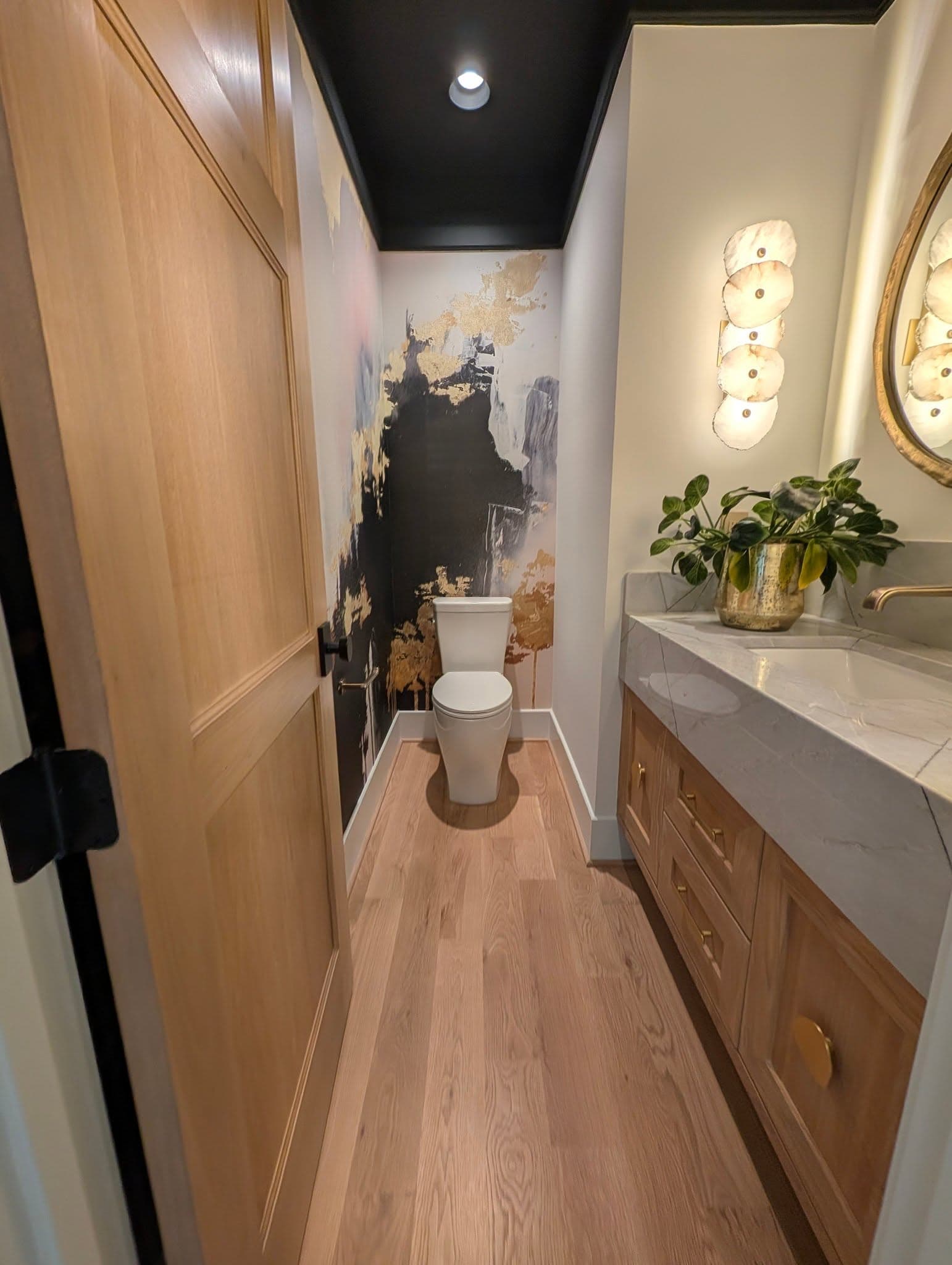 Wide-plank hardwood in a powder room with a matching wood vanity, a job by Alabama Hardwood Restoration