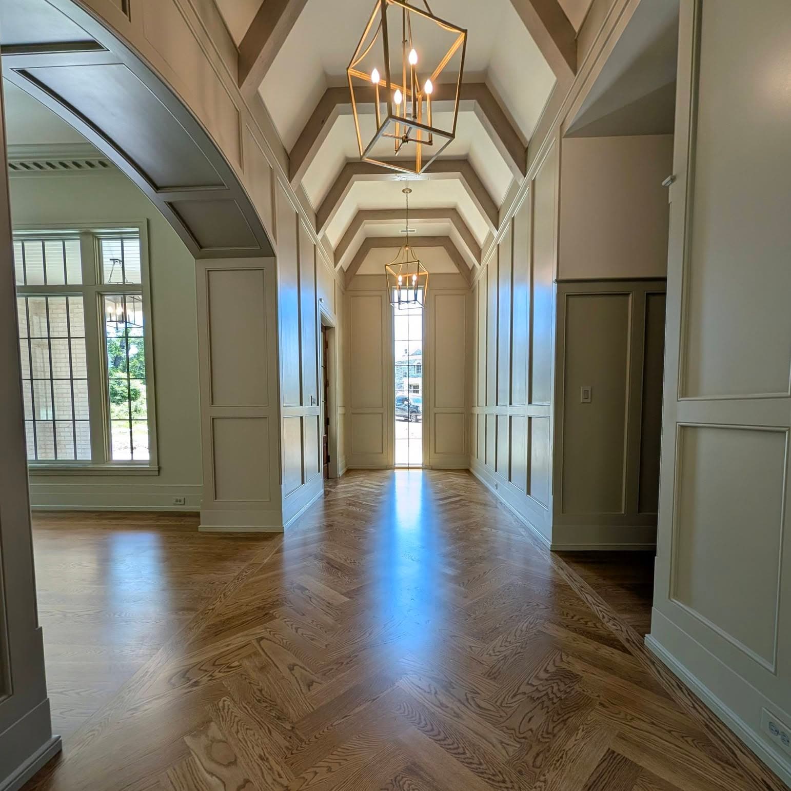 Herringbone oak hardwood floor in a vaulted paneled hallway, a job by Alabama Hardwood Restoration