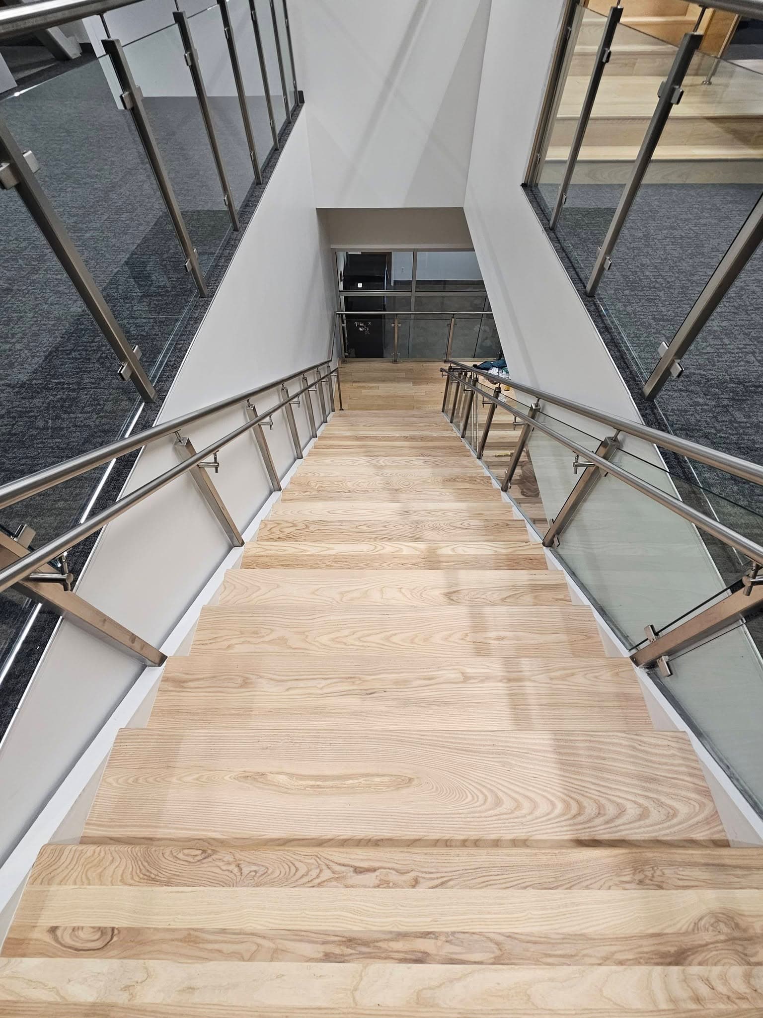 Looking up commercial hardwood stair treads at Mazda Toyota manufacturing in North Alabama, a stair replacement by Alabama Hardwood Restoration