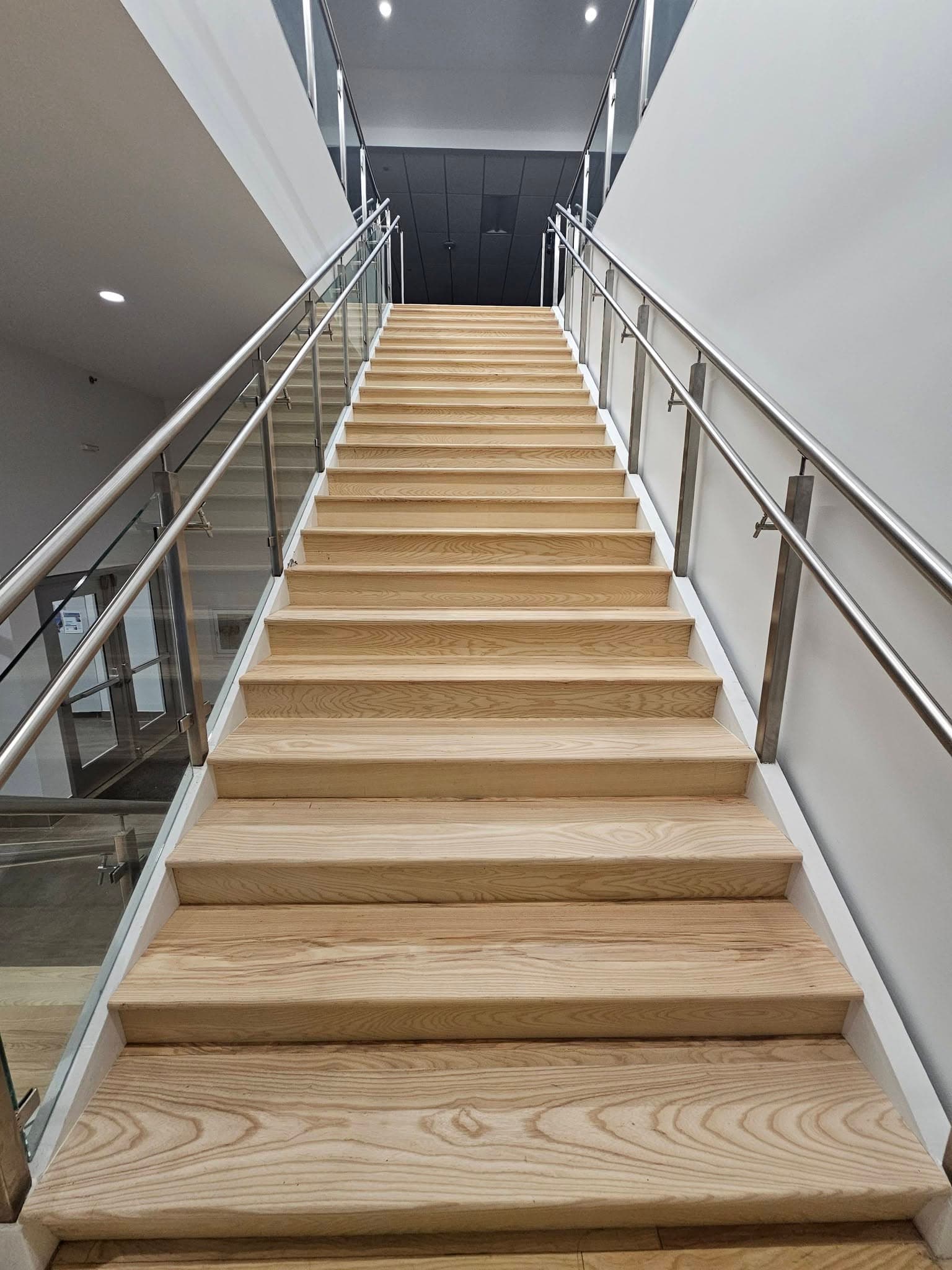 Commercial hardwood stairs from the bottom at Mazda Toyota manufacturing in North Alabama, a stair replacement by Alabama Hardwood Restoration